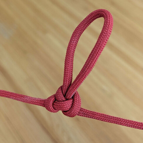 A length of red paracord knotted to produce an inline loop.